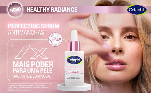 Uma mulher loira com pele clara e maquiagem natural olha diretamente para a c&acirc;mera, com a m&atilde;o direita tocando levemente o rosto. No canto inferior esquerdo, um frasco de s&eacute;rum branco e rosa da Cetaphil, com a tampa dourada, est&aacute; em destaque sobre um pedestal branco. O texto "NOVO HEALTHY RADIANCE" e "PERFECTING SERUM ANTIMANCHAS" aparece na parte superior. H&aacute; tamb&eacute;m um selo "MADE IN KOREA" e a indica&ccedil;&atilde;o "7X MAIS PODER PARA UMA PELE RADIANTE E LUMINOSA".
