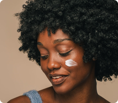 Mulher sorrindo com creme contendo ceramidas na pele.