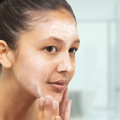 Mulher aplicando sabonete com &aacute;cido salic&iacute;lico
