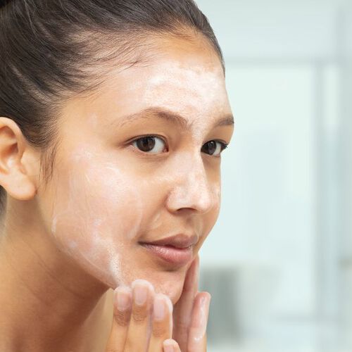Mulher lavando o rosto com sabonete com &aacute;cido salic&iacute;lico Cetaphil Oil Control.